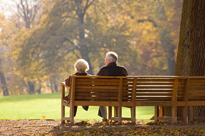 2 people sitting on a park bench